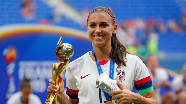 Alex Morgan with the World Cup trophy and silver boot.