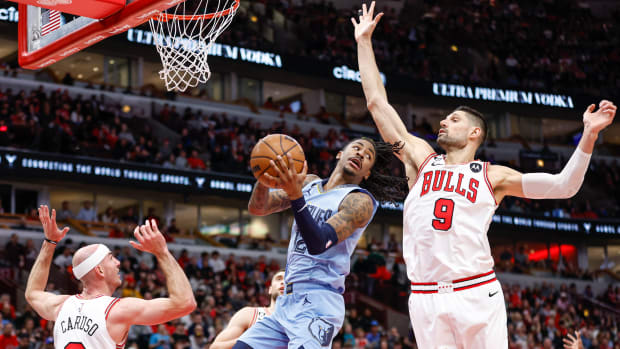 Apr 2, 2023; Chicago, Illinois, USA; Memphis Grizzlies guard Ja Morant (12) looks to pass the ball against Chicago Bulls center Nikola Vucevic (9) during the first half at United Center.