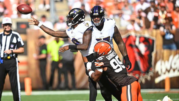 Oct 1, 2023; Cleveland, Ohio, USA; Baltimore Ravens quarterback Lamar Jackson (8) throws a pass as he is hit by Cleveland Browns defensive end Myles Garrett (95) in the third quarter at Cleveland Browns Stadium.