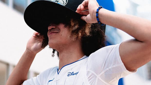 Former Arkansas guard Anthony Black tries on an oversized hat provided by the Orlando Magic to accommodate his iconic hair.