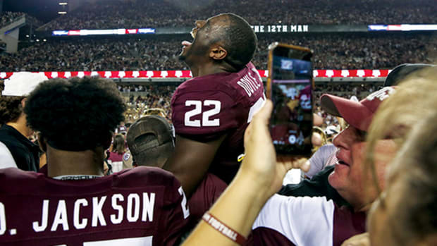 Texas A&M Aggies linebacker Antonio Doyle Jr. laughs as players and fans rush the field after beating Alabama at Kyle Field.