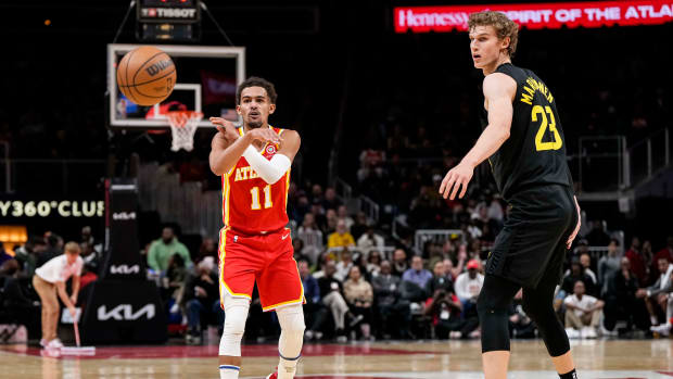 Hawks guard Trae Young passes the ball past Jazz forward Lauri Markkanen.