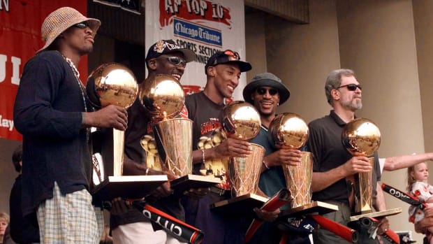 June 16, 1997; Ron Harper, Dennis Rodman, Scottie Pippen, Michael Jordan and head coach Phil Jackson hold up the Chicago Bulls' five championship trophies at a rally in Grant Park