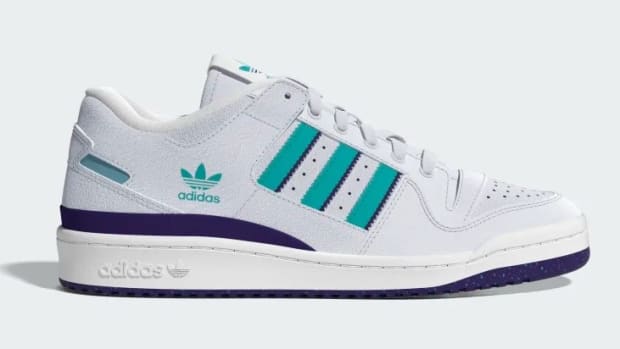 Side view of a white, teal, and purple adidas shoe.