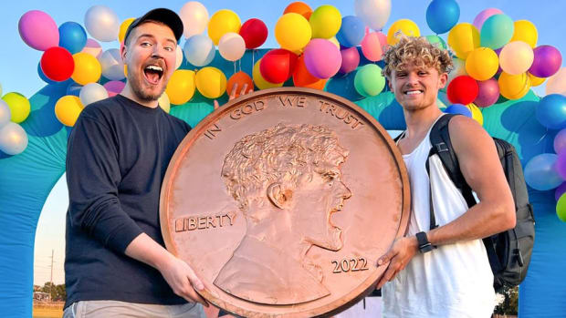 Ryan Trahan presents Mr. Beast with a giant penny.