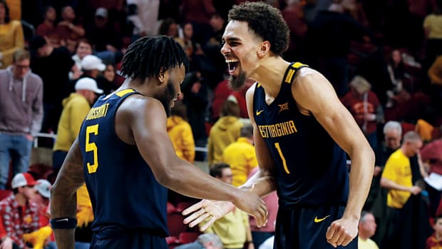 West Virginia Mountaineers forward Emmitt Matthews Jr., guard Joe Toussaint celebrate after their win over the Iowa State Cyclones at James H. Hilton Coliseum.