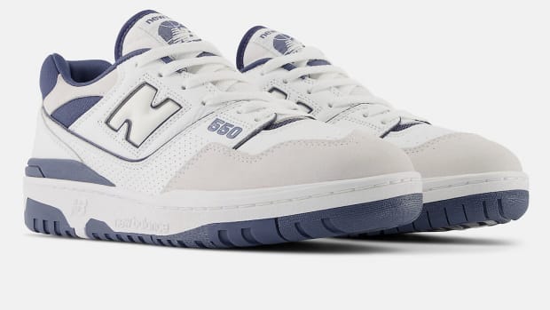 Side view of white and indigo New Balance sneakers.