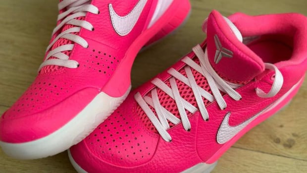 Side view of pink and white Nike Kobe sneakers.