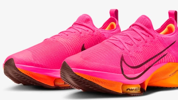 View of pink and orange Nike running shoes.