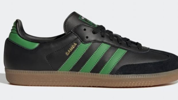 Side view of black and green adidas shoe.