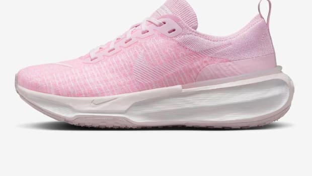 Side view of pink and white Nike running shoe.