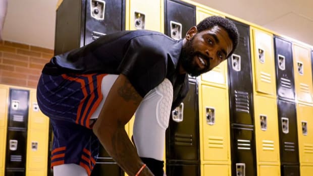 Kyrie Irving ties his sneakers before a Drew League basketball game.