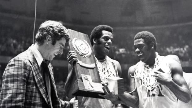 Indiana head coach Bobby Knight celebrates with forward Scott May (center) and guard Quinn Buckner (21) after winning the 1976 NCAA basketball championship. The Hoosiers beat the Wolverines 86-68.