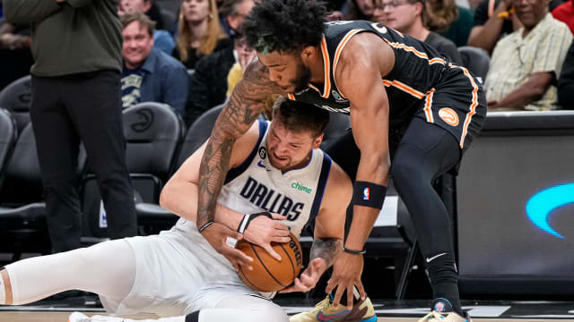 Dallas Mavericks guard Luka Doncic and Atlanta Hawks forward Saddiq Bey fight for a loose ball.