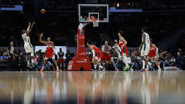 Milwaukee Bucks forward Khris Middleton (22) shoots the ball over Washington Wizards guard Jordan Poole (13) 