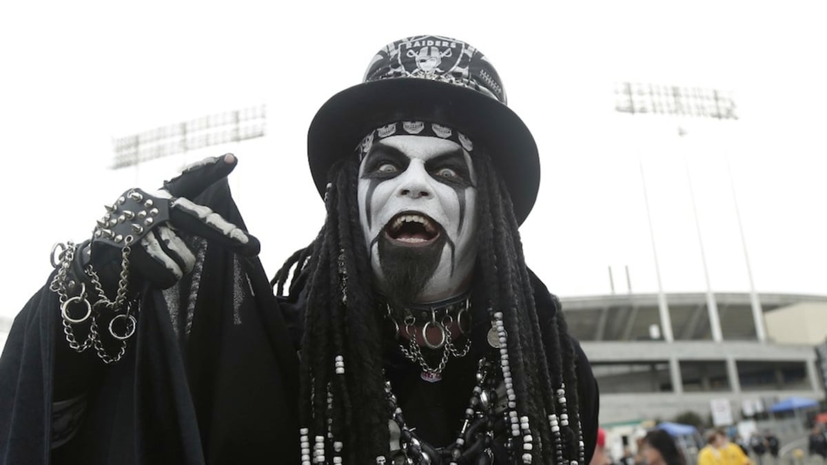 A fan of the Oakland Raiders wear an armored costume and skeleton