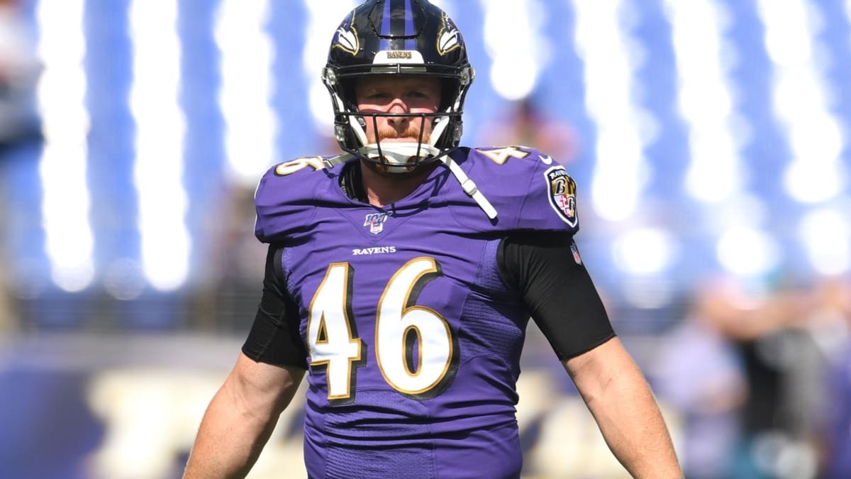 Baltimore Ravens long snapper Morgan Cox (46) waits to take the field while  holding a flag as part of the team's Salute to Service prior to an NFL  football game against the