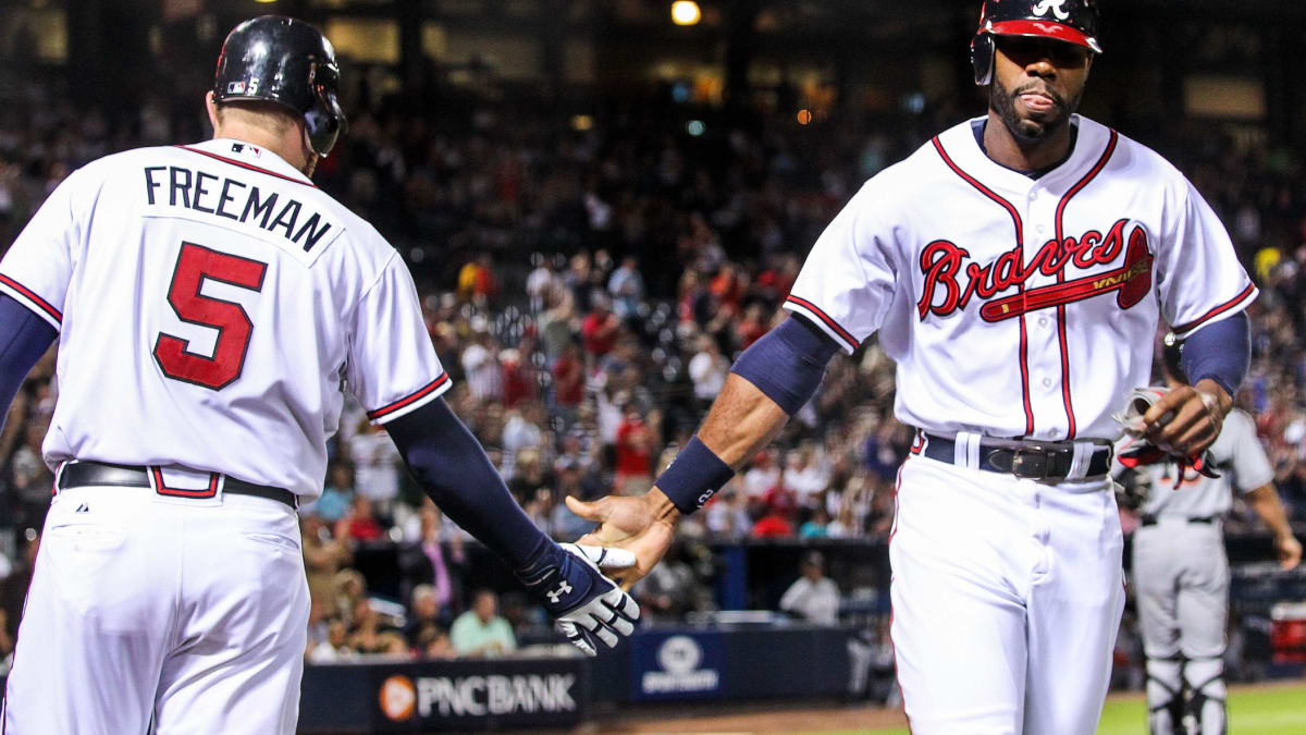 Atlanta Braves' Jason Heyward (R) gets a hug from teammate Freddie