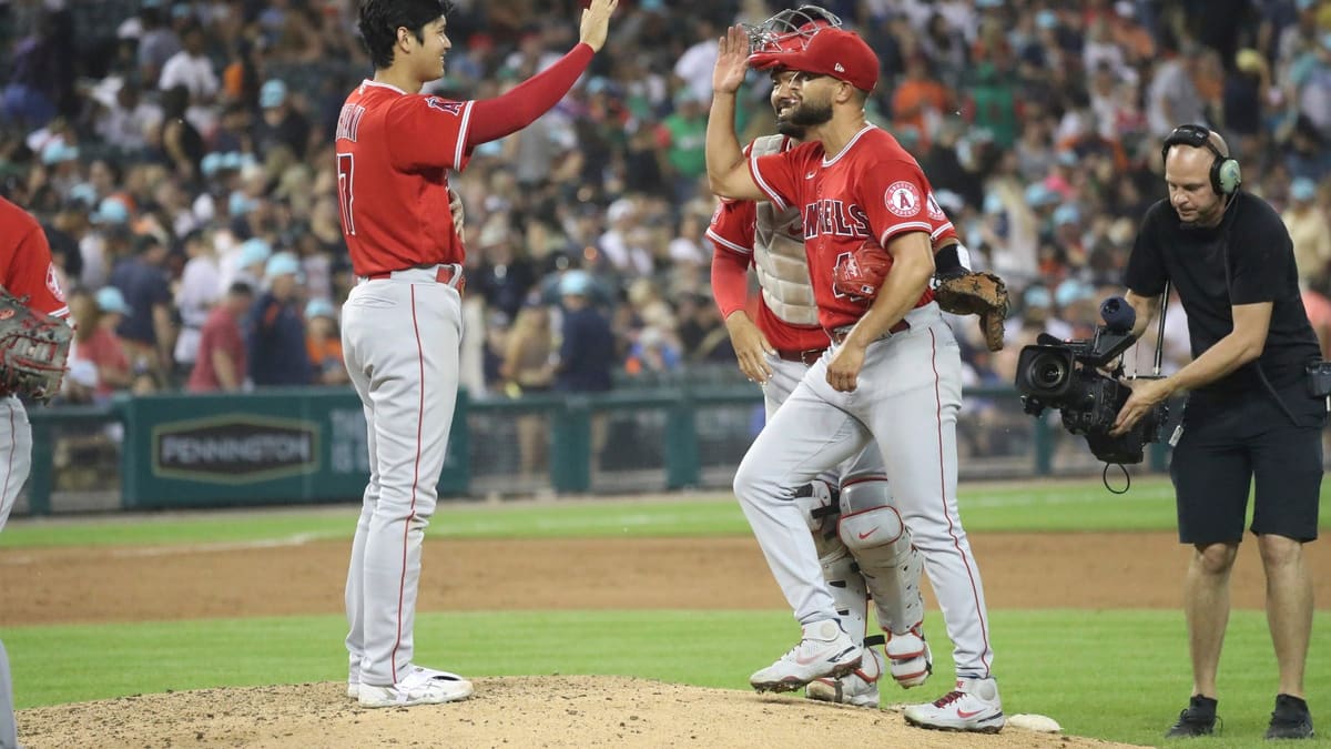 Shohei Ohtani (R) of the Los Angeles Angels hands his protective gear to a  ball boy after drawing a walk during the first inning of a baseball game  against the Texas Rangers