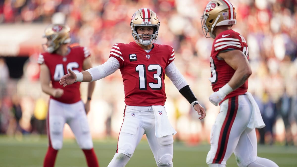 San Francisco 49ers defensive players hit a goal post with a logo