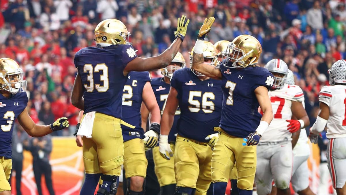 Notre Dame quarterback Ian Book and Liam Eichenberg celebrate a