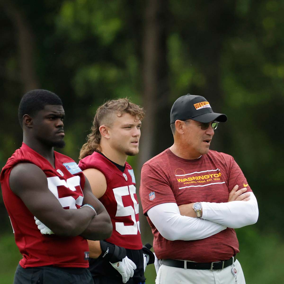 Washington Football Team first round draft pick, linebacker Jamin Davis  (52) and defensive end Chase Young (99) talk during an NFL football  practice at Inova Sports Performance Center in Ashburn, Va., Wednesday