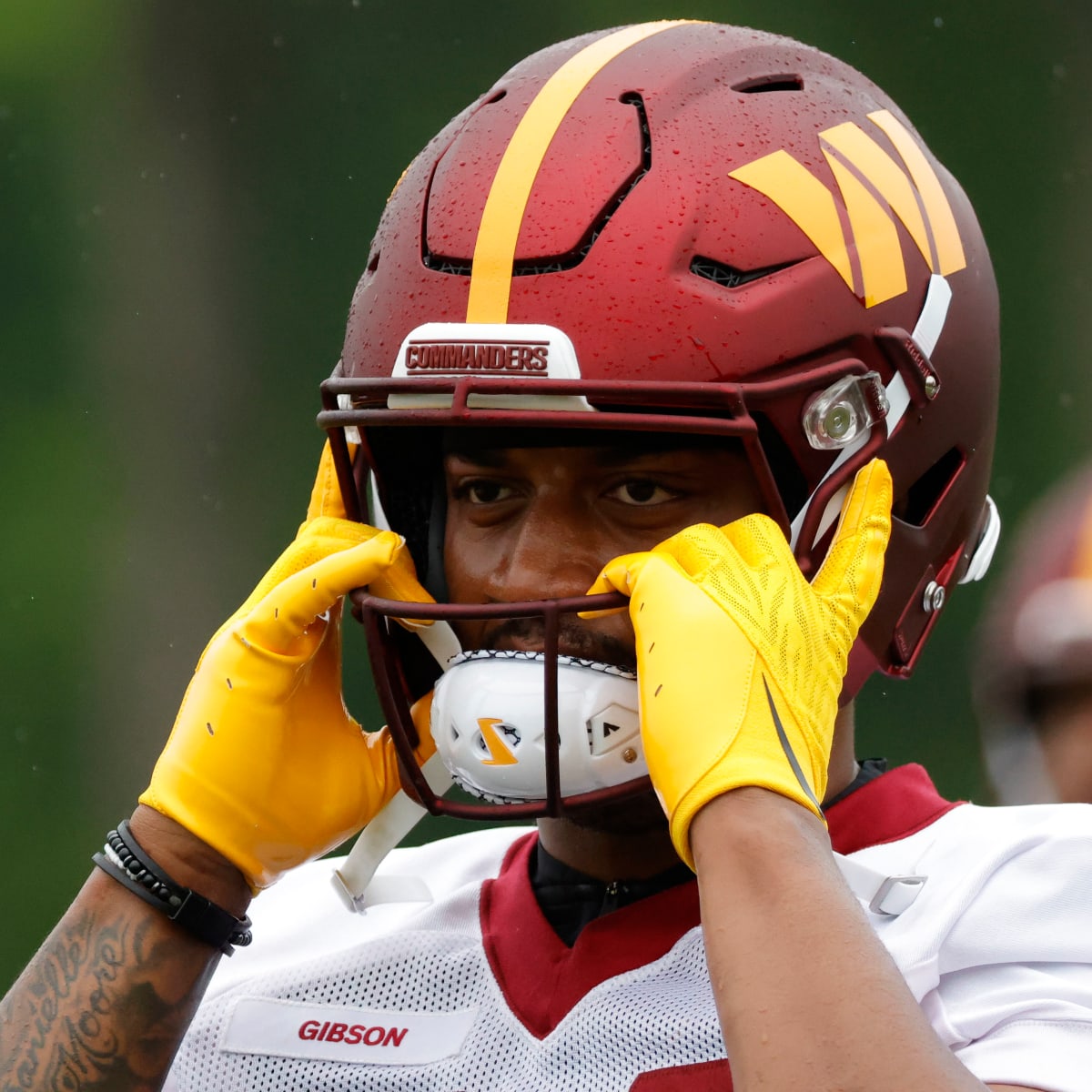 Washington Football Team running back Antonio Gibson (24) clutches the  football as he is tackle …