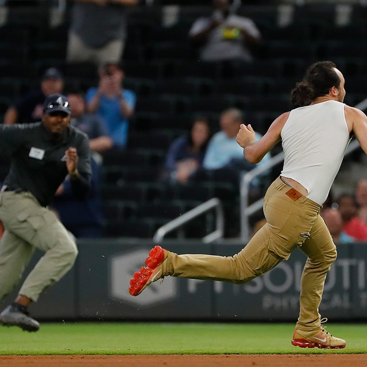 Fans run onto field and one makes contact with Atlanta Braves star
