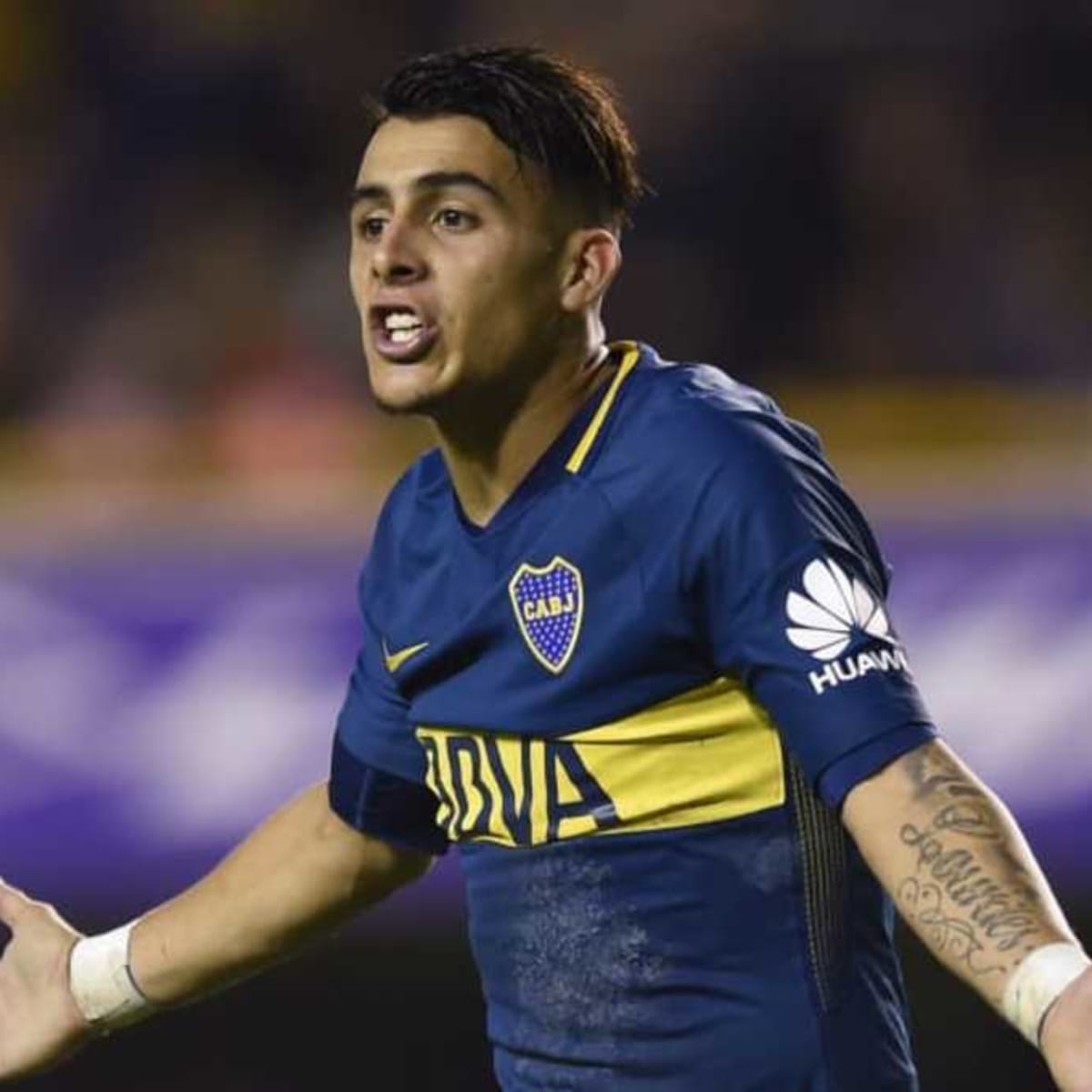 Forward Cristian Pavón, middle, of Argentina, holds up his new LA