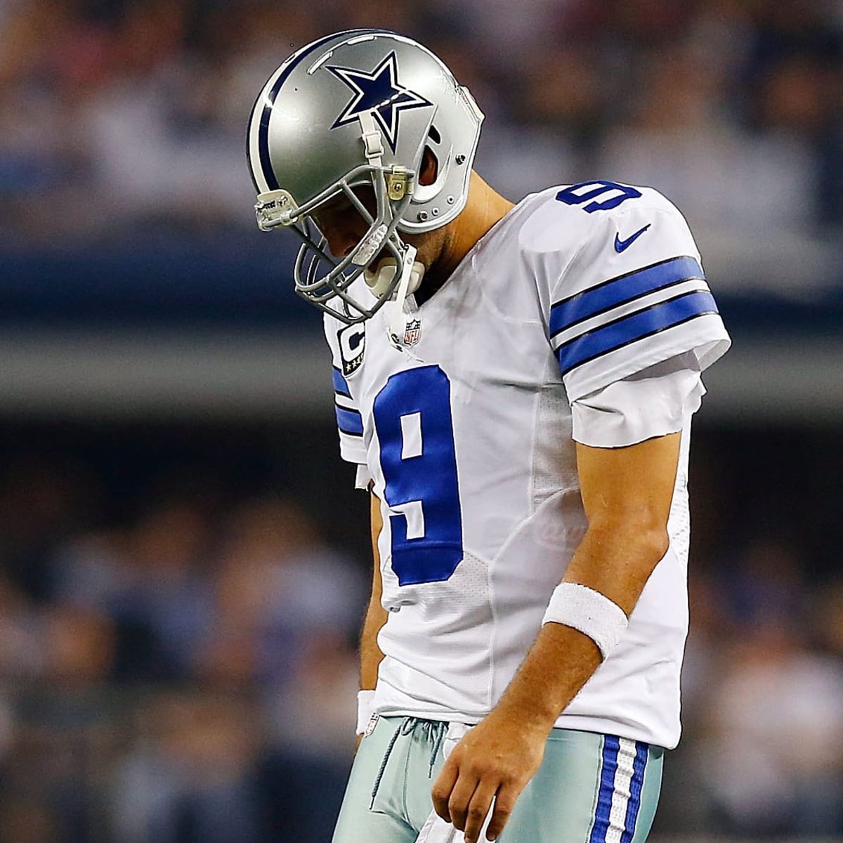 FILE - In this Tuesday, June 17, 2014, file photo, Dallas Cowboys  quarterback Tony Romo, playfully covers his number after exchanging his  jersey with a teammate during an NFL football minicamp in