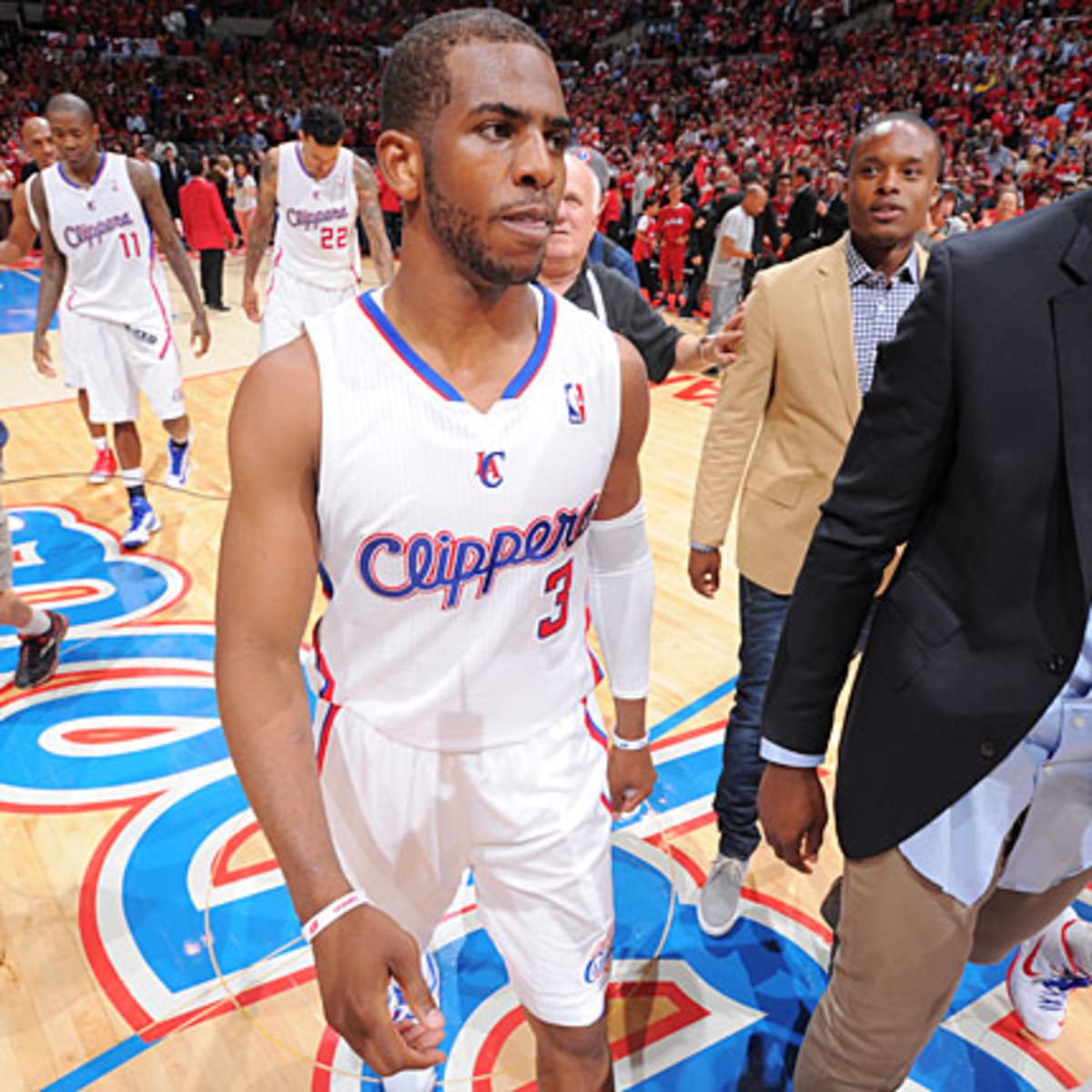 Chris Paul smiles in light blue Clippers jersey holding ball with