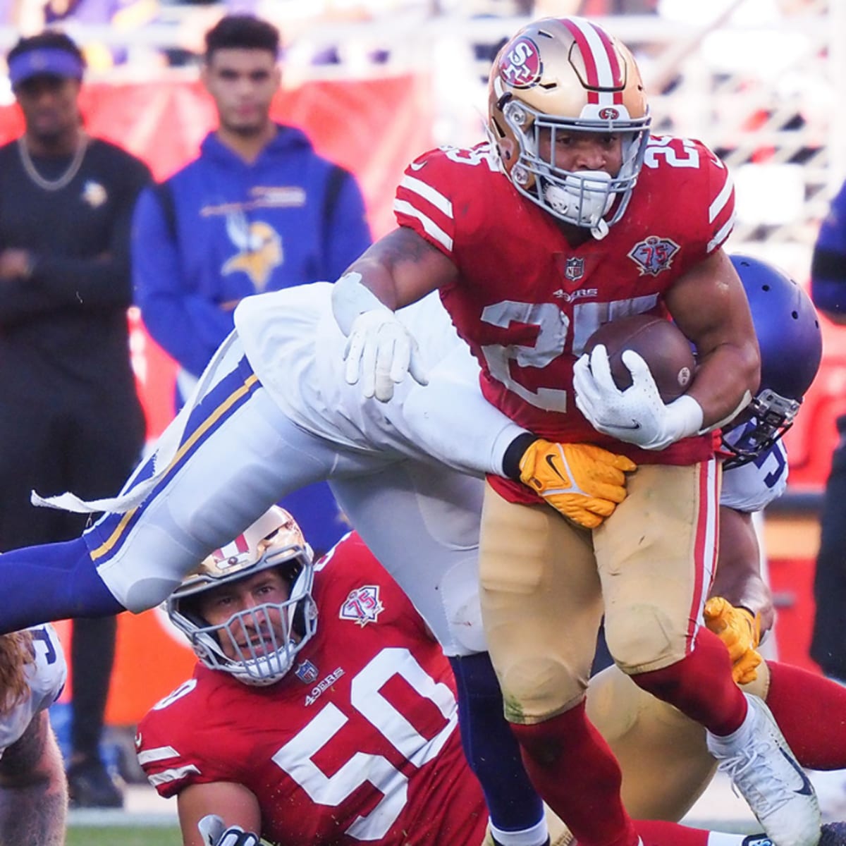 San Francisco 49ers running back Elijah Mitchell, top, is tackled by Dallas  Cowboys defensive e …