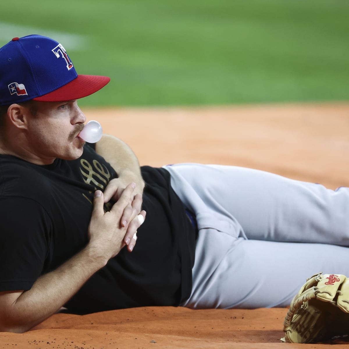 Texas Rangers third baseman Brock Holt (16) blows a bubble during