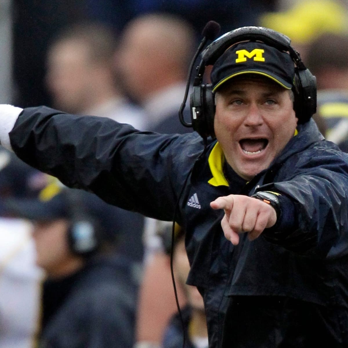 Head coach Rich Rodriguez of the Michigan Wolverines is flanked by News  Photo - Getty Images