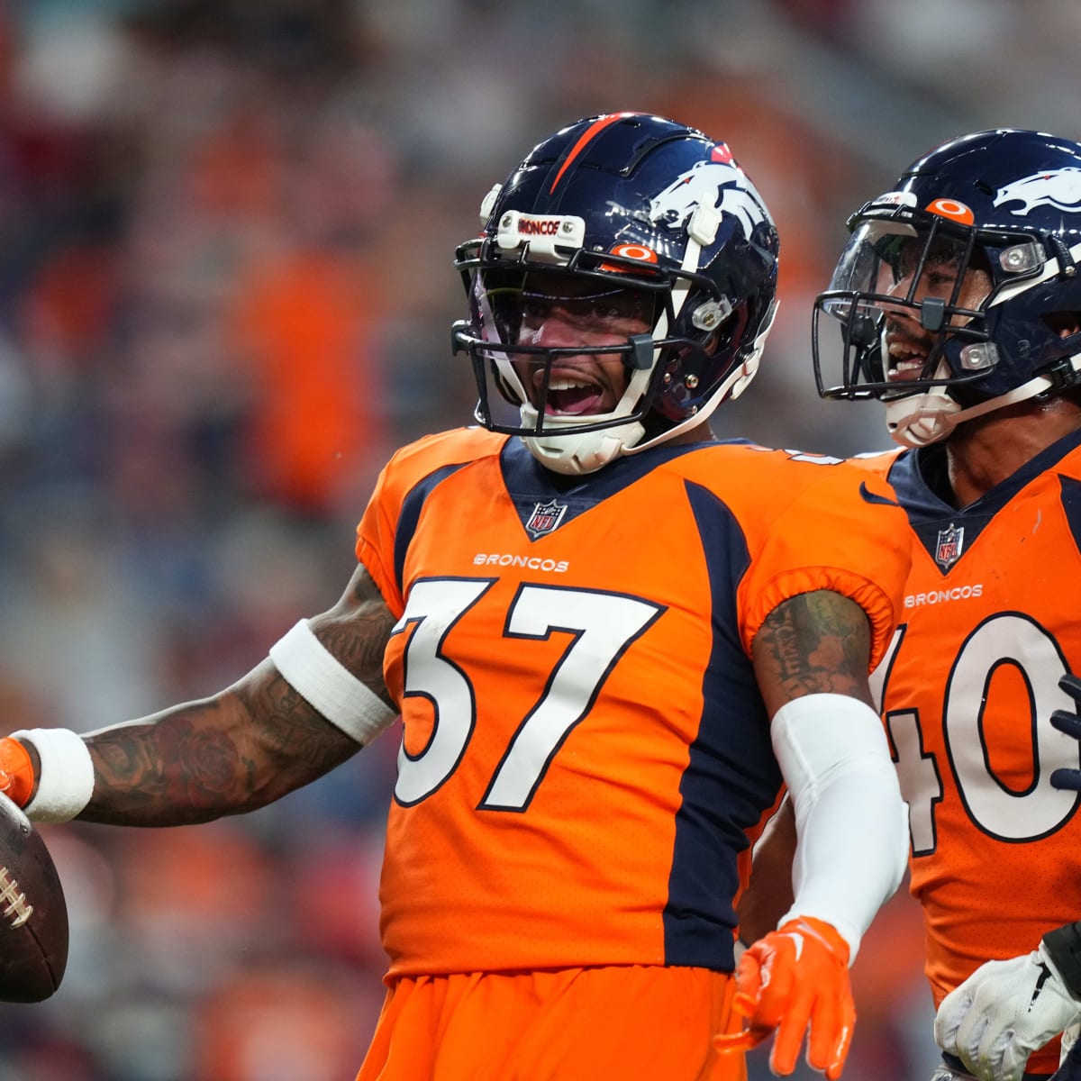 Justin Simmons and PJ Locke of the Denver Broncos run through