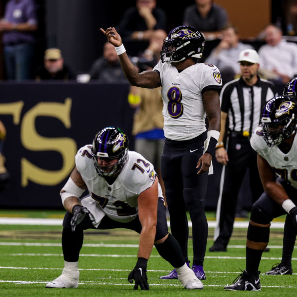 Baltimore Ravens quarterback Lamar Jackson (8) takes to the field with a  member of the military as part of Salute to Service before an NFL football  game against the Carolina Panthers, Sunday