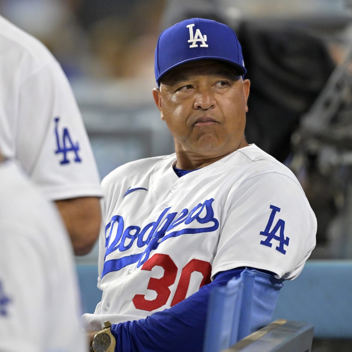 Los Angeles Dodgers' Dave Roberts walks in the dugout wearing a new Los Dodgers  uniform before a baseball game against the New York Mets in Los Angeles,  Saturday, Aug. 21, 2021. (AP