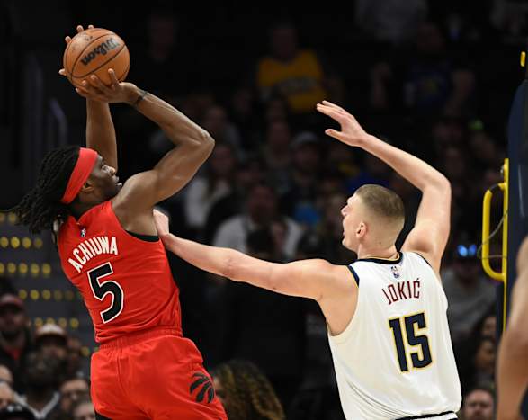 Denver Nuggets center Nikola Jokic (15) puts his hand on the chest of Toronto Raptors forward Precious Achiuwa (5) as he takes a shot during the first quarter at Ball Arena