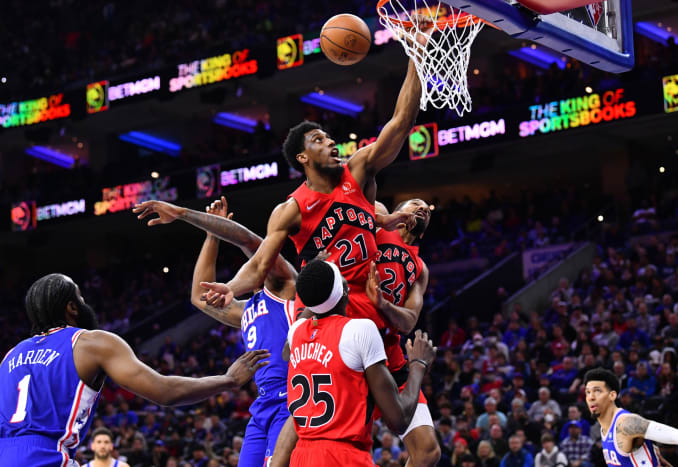 Toronto Raptors forward Thaddeus Young (21) grabs the rim after missing a shot over Philadelphia 76ers center DeAndre Jordan (9) in the second quarter at Wells Fargo Center