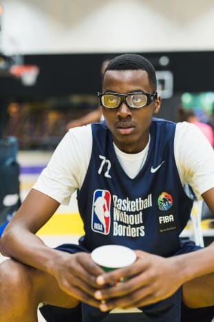 Christian Koloko, the Toronto Raptors' 2022 second-round pick, holds a glass of water at the 2018 Basketball Without Borders event in Los Angeles