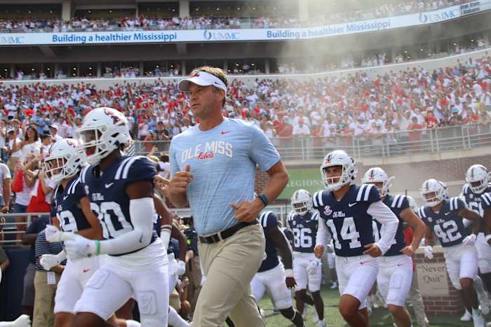 Lane Kiffin running out with Ole Miss Football.