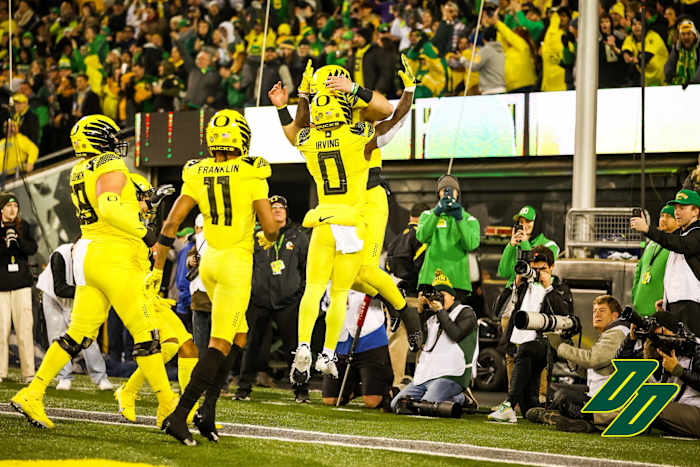 Oregon Ducks quarterback Bo Nix celebrates a touchdown with Bucky Irving (0) and his teammates.