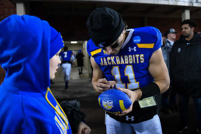 SDSU's quarterback Mark Gronowski (11) signs a football for a kid after winning the FCS semifinals on Friday, Dec. 15, 2023 at Dana J. Dykhouse in Brookings.