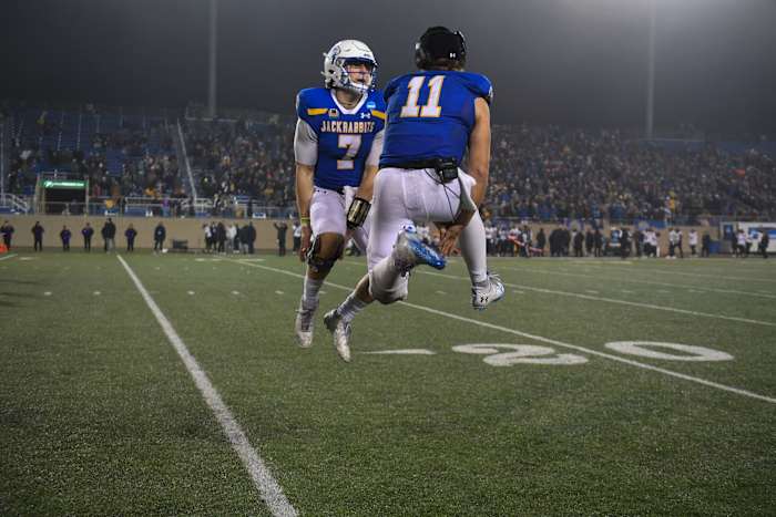 SDSU's quarterback Chase Mason and quarterback Mark Gronowski (11) celebrate the win against UAlbany on Friday, Dec. 15, 2023 at Dana J. Dykhouse in Brookings.