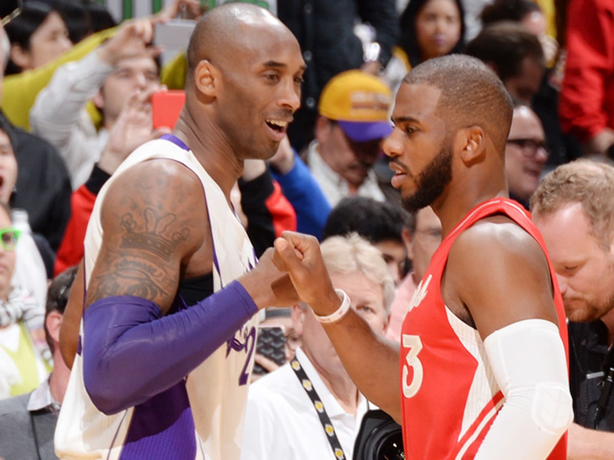 Kobe Bryant in street clothes talks to Chris Paul before the 2014