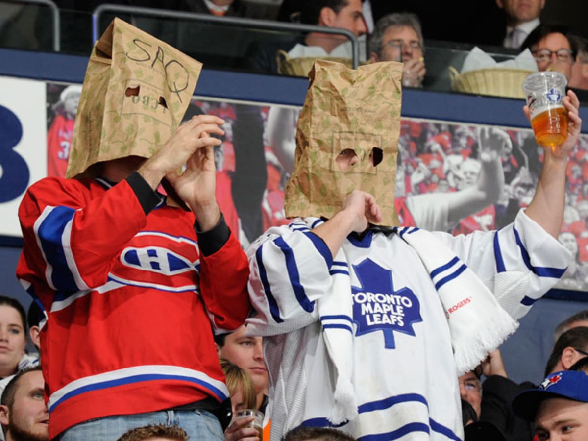 New York Mets fans, one wearing a paper bag over their head, watch