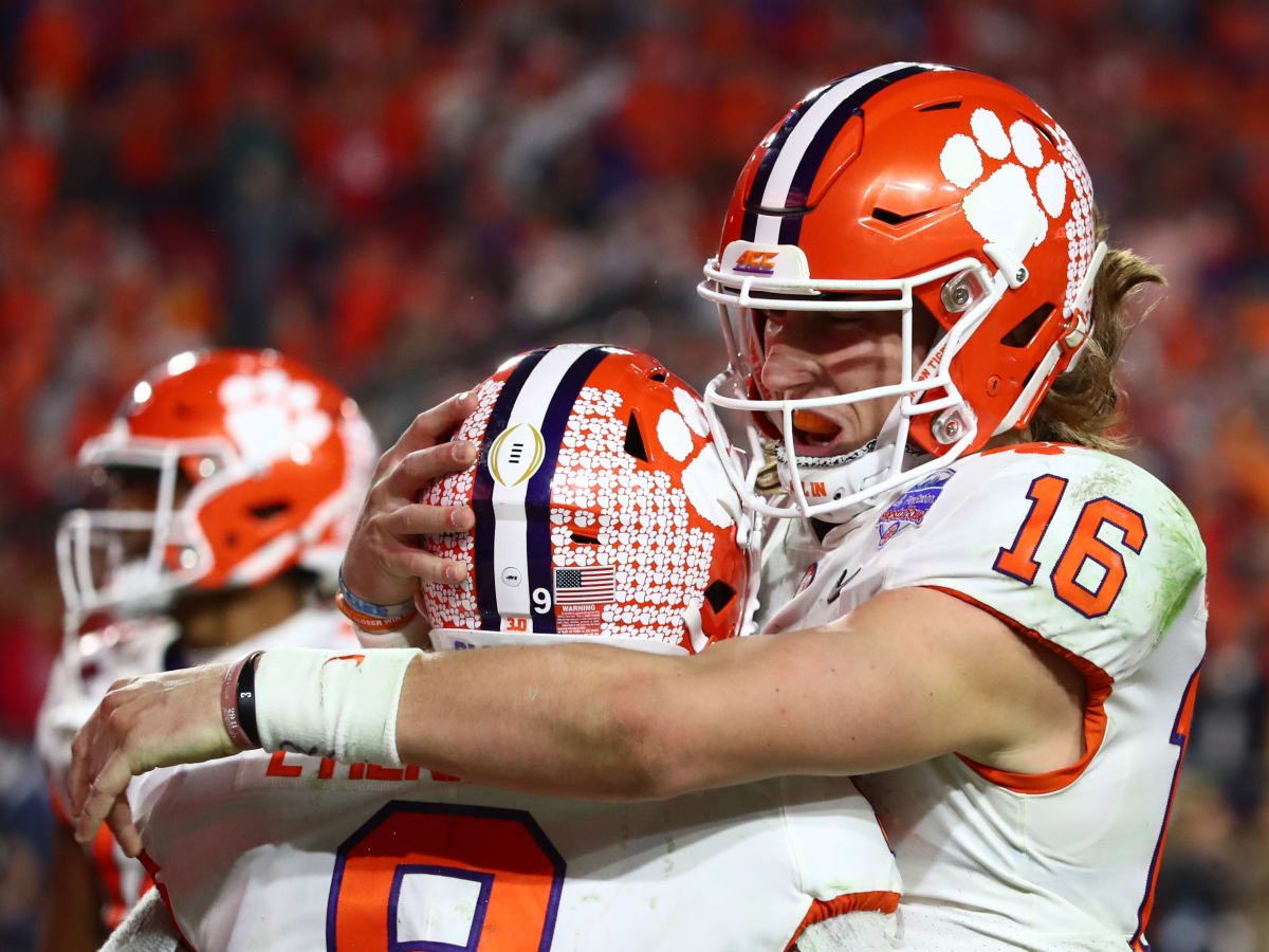 Clemson's Trevor Lawrence (16) hands the ball off to Travis Etienne (9)  during the first half of an NCAA college football game against North  Carolina State in Raleigh, N.C., Saturday, Nov. 9