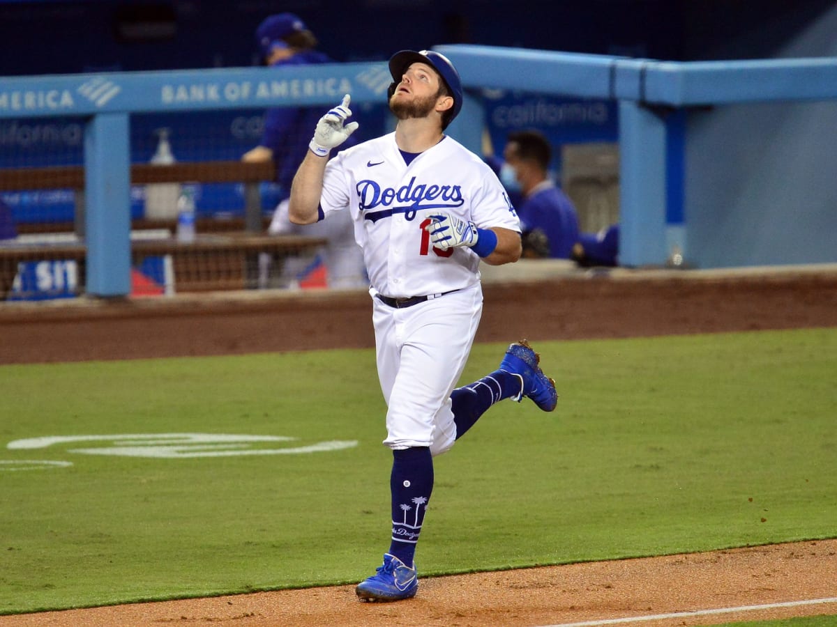 Los Angeles Dodgers' Max Muncy fixes his cap while wearing a new