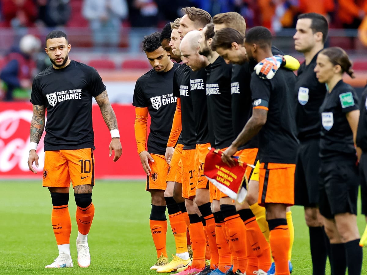  The Dutch team lines up before the Euro 2008 match wearing black T-shirts with the slogan 'Football Supports Change'.