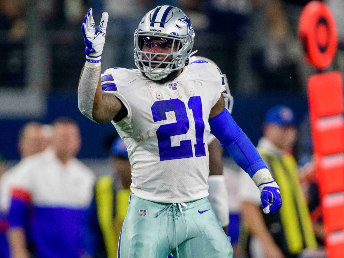 Ezekiel Elliott of the Dallas Cowboys signs his jersey after the